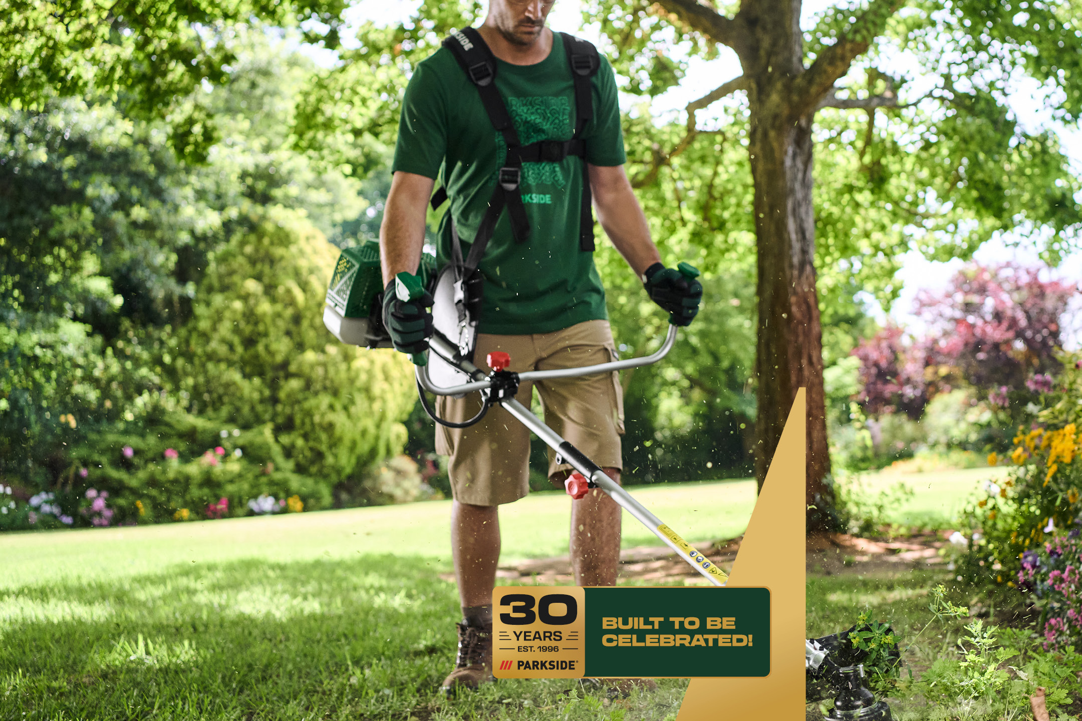 Person trimming grass with a string trimmer, celebrating 30 years of quality.
