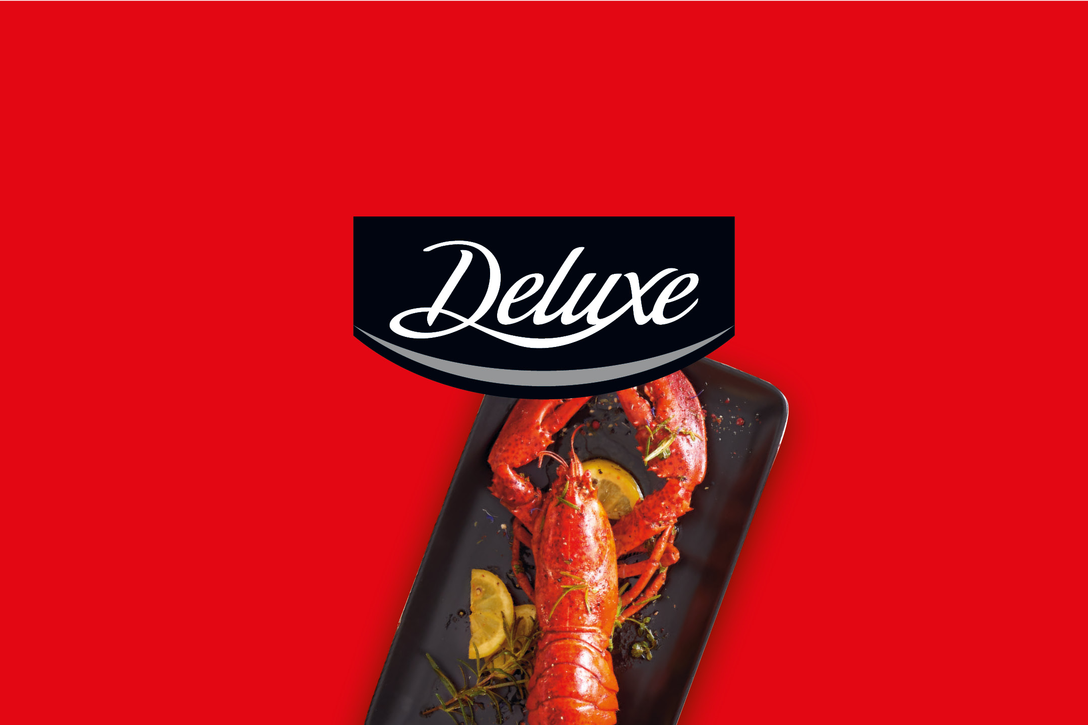 Cooked whole lobster served on a black plate with lemon slices on a red background.