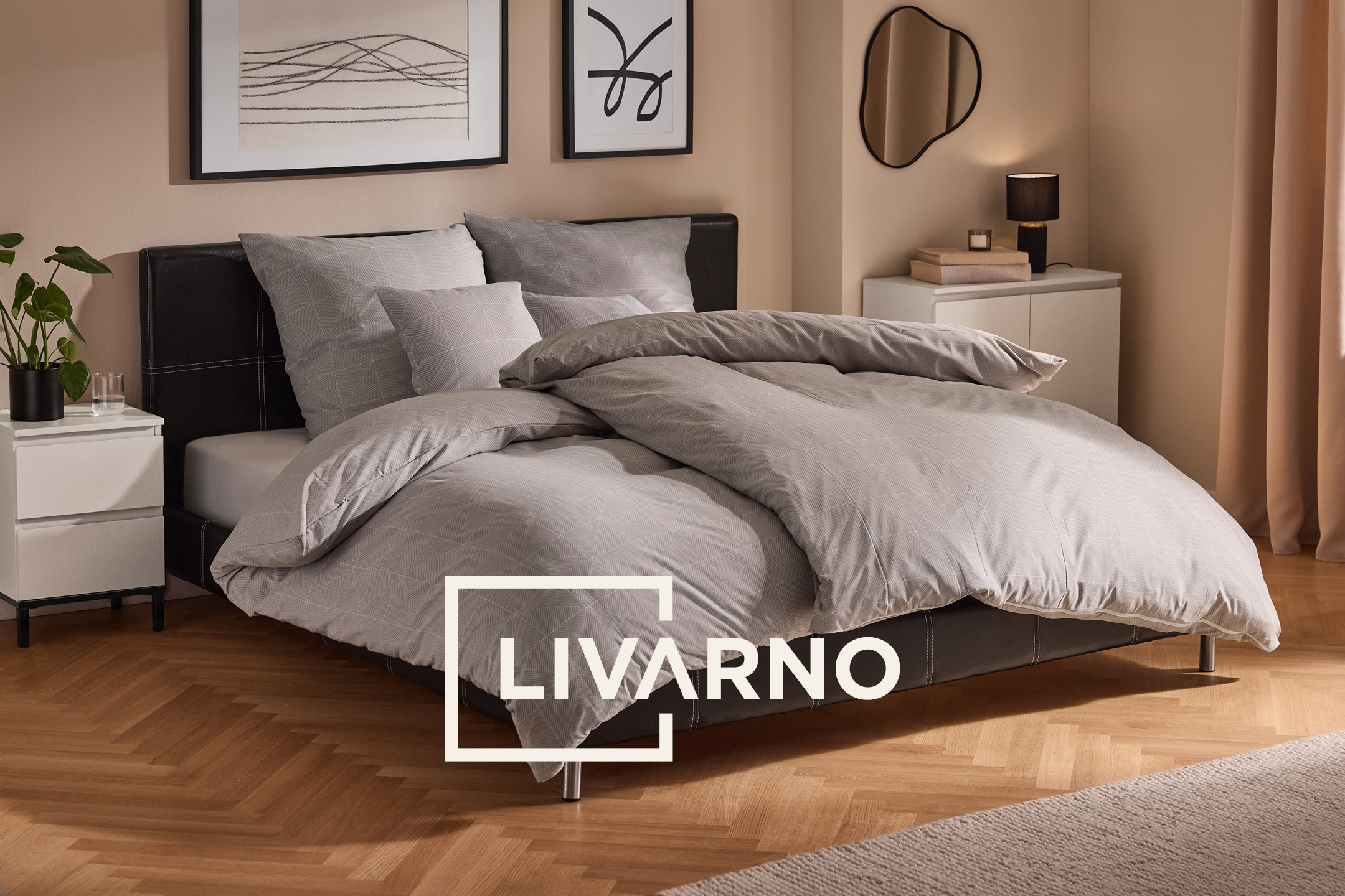 Grey patterned bedding set on a double bed in a modern bedroom.