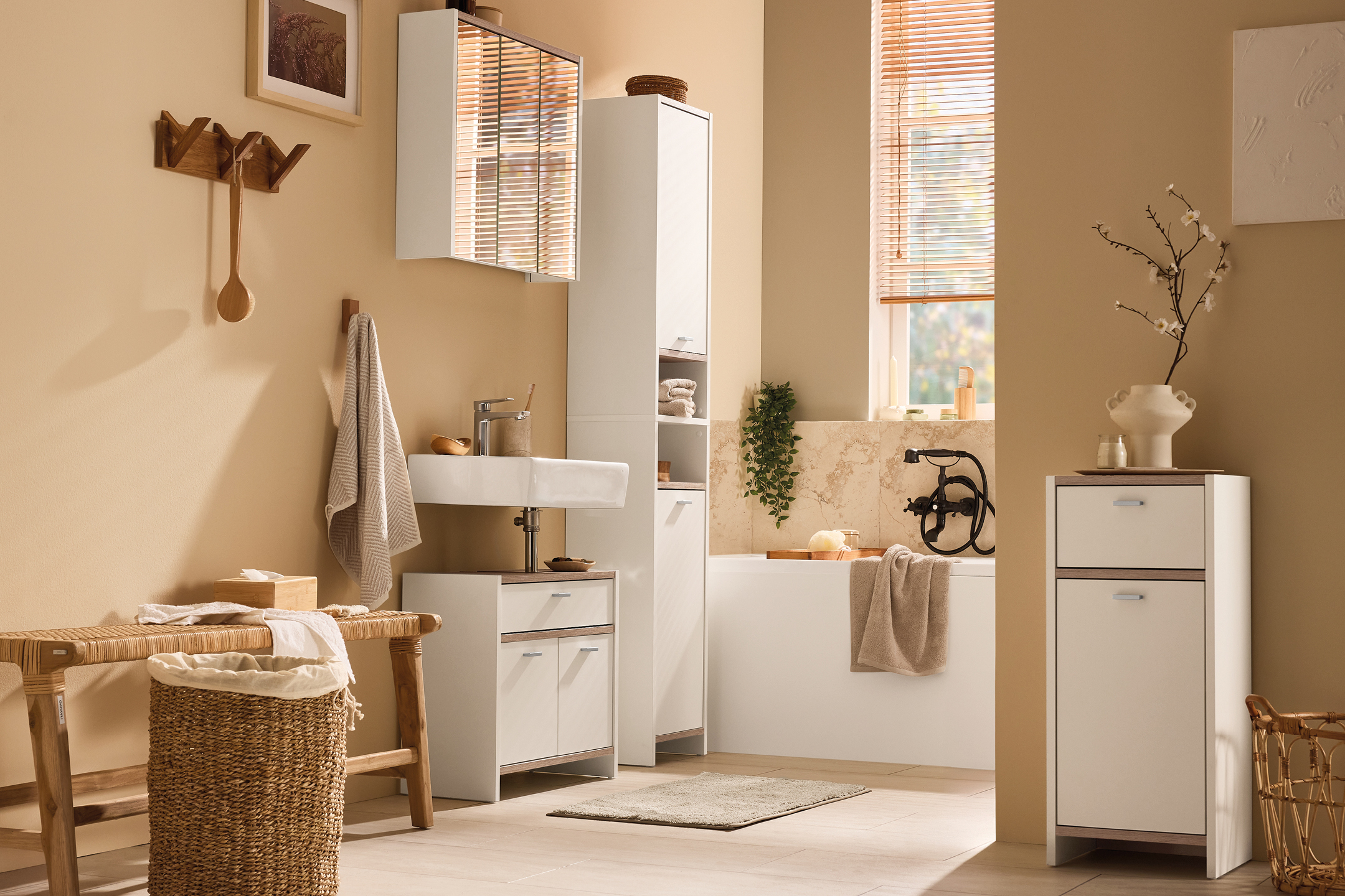 Modern bathroom with white cabinets, a sink, bathtub, and wooden accents.