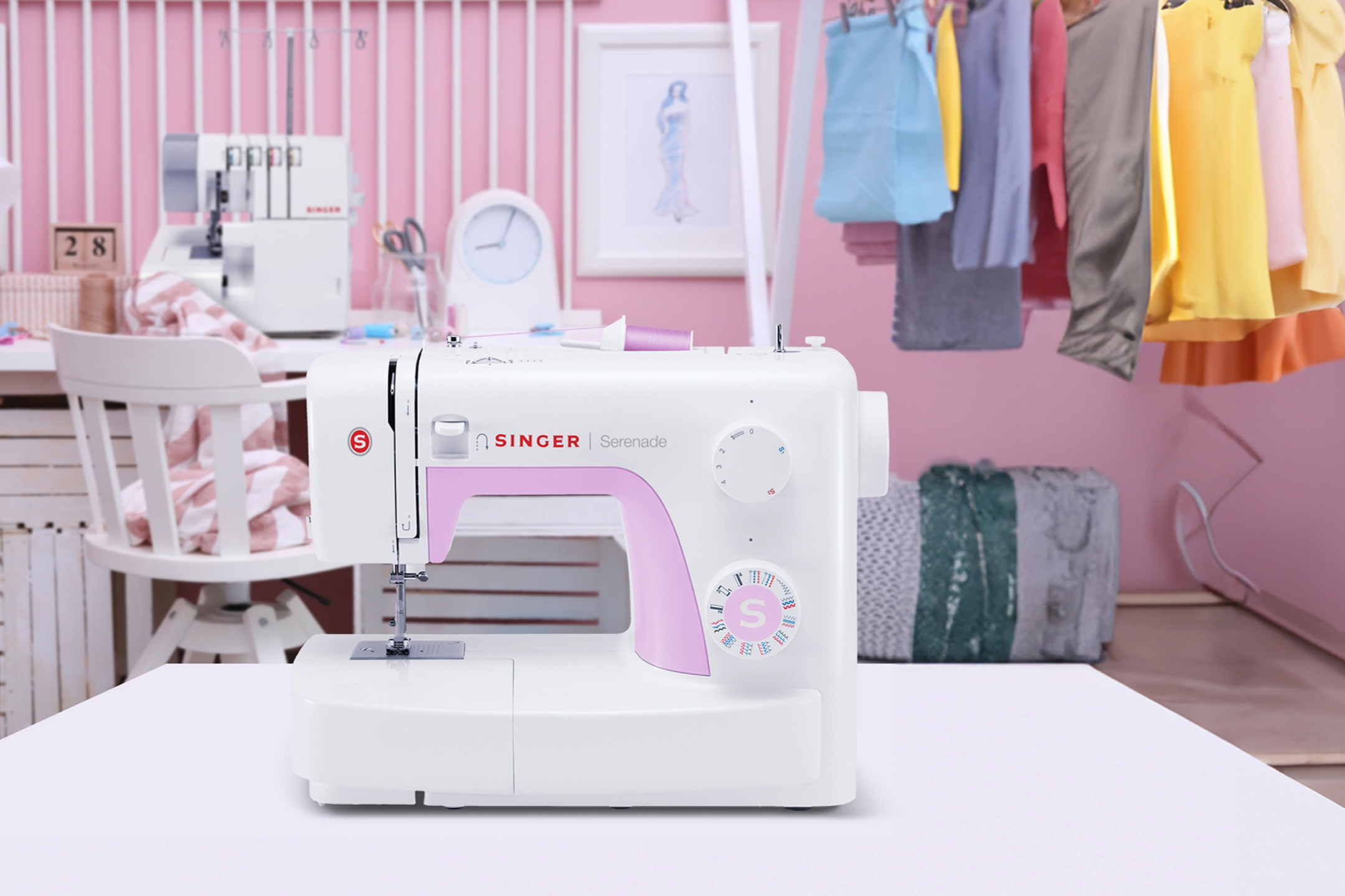 White and pink SINGER Serenade sewing machine on a table in a pink-themed sewing room.