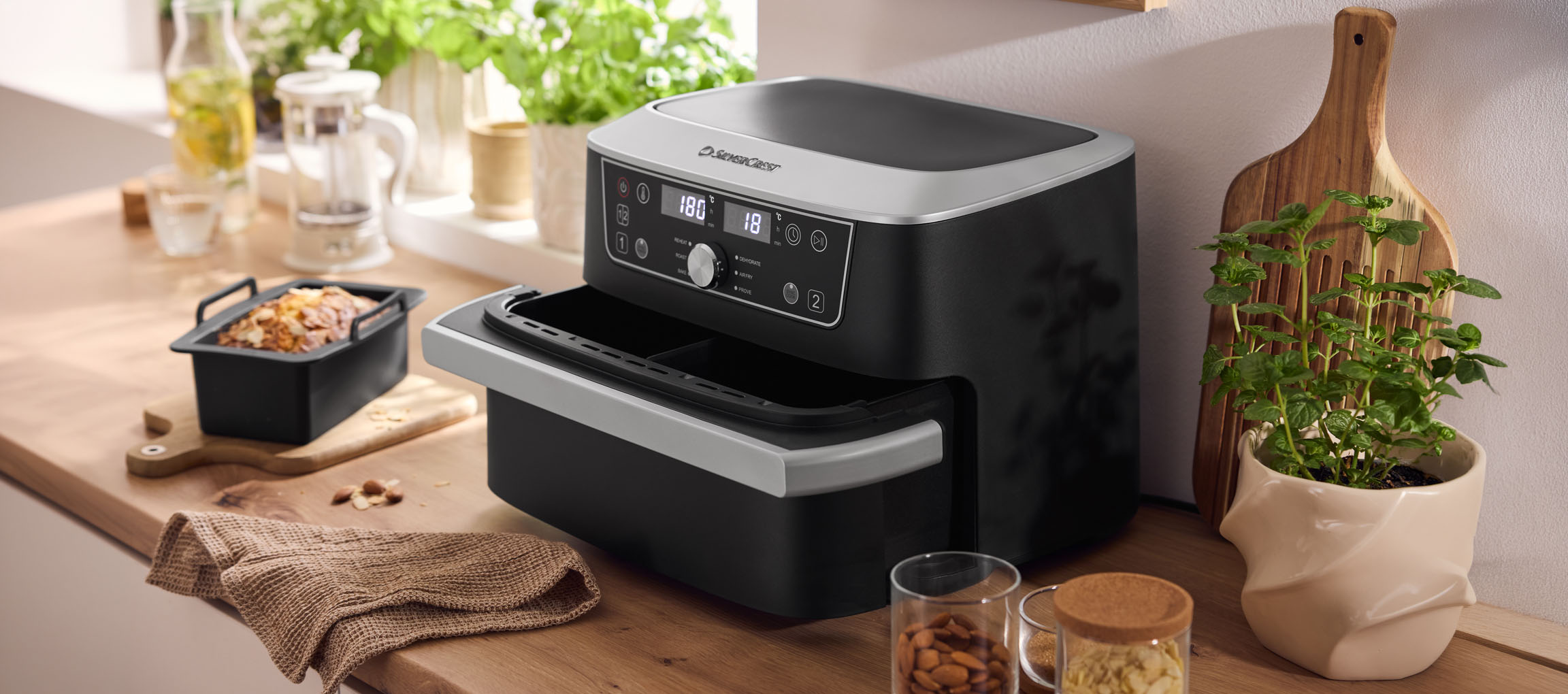Black air fryer with a double oven and a baked good on a wooden countertop.