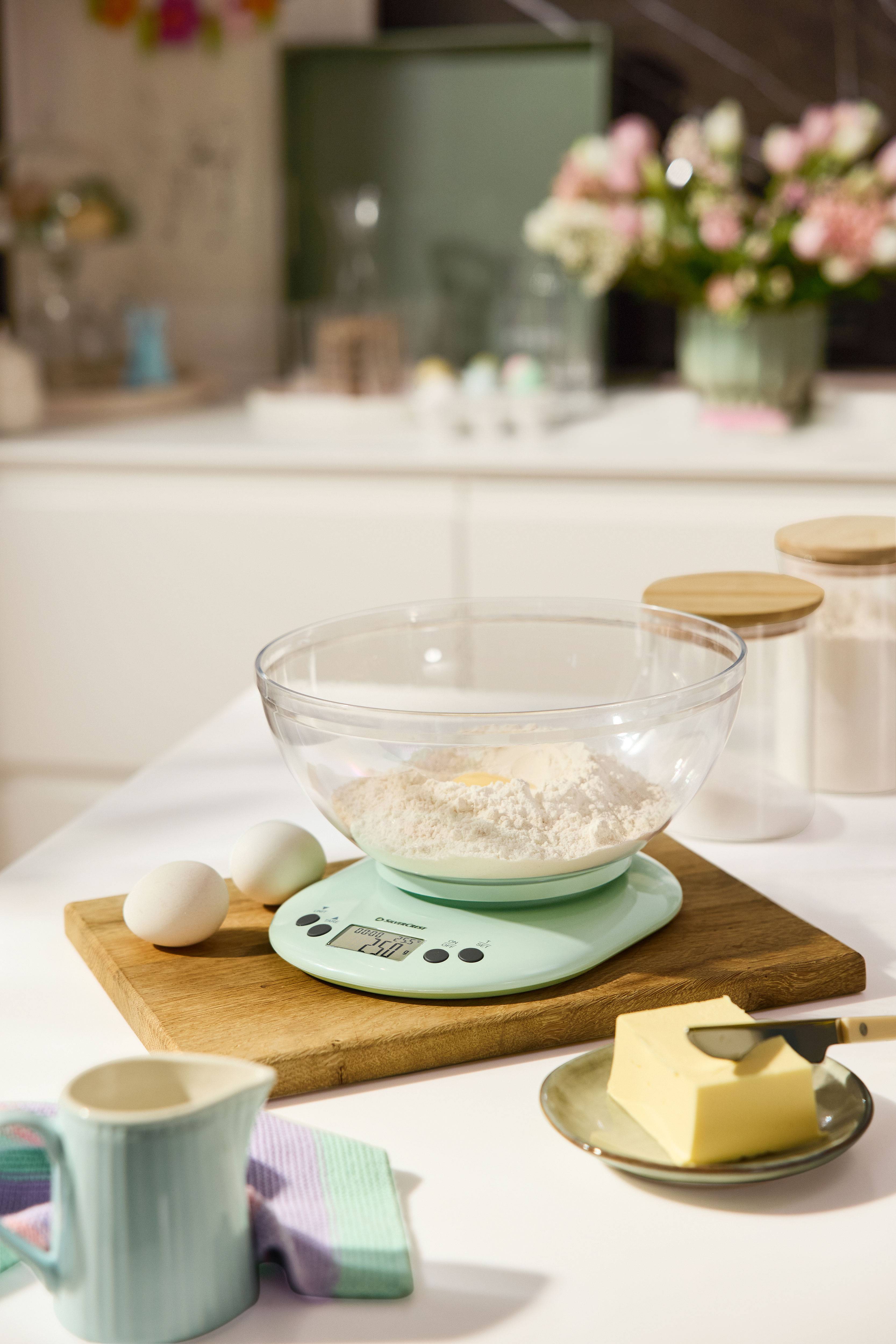 SilverCrest kitchen scale with bowl, flour, eggs, and butter on a wooden board.