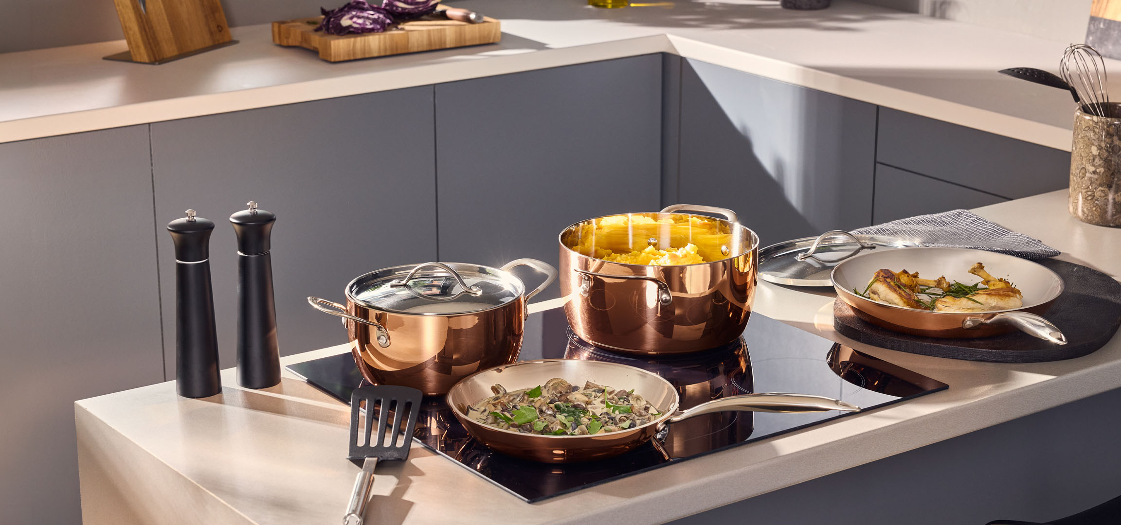 aiLabeling.aiLabelForImageAltText: Copper-colored pots and pans with food on an induction hob.