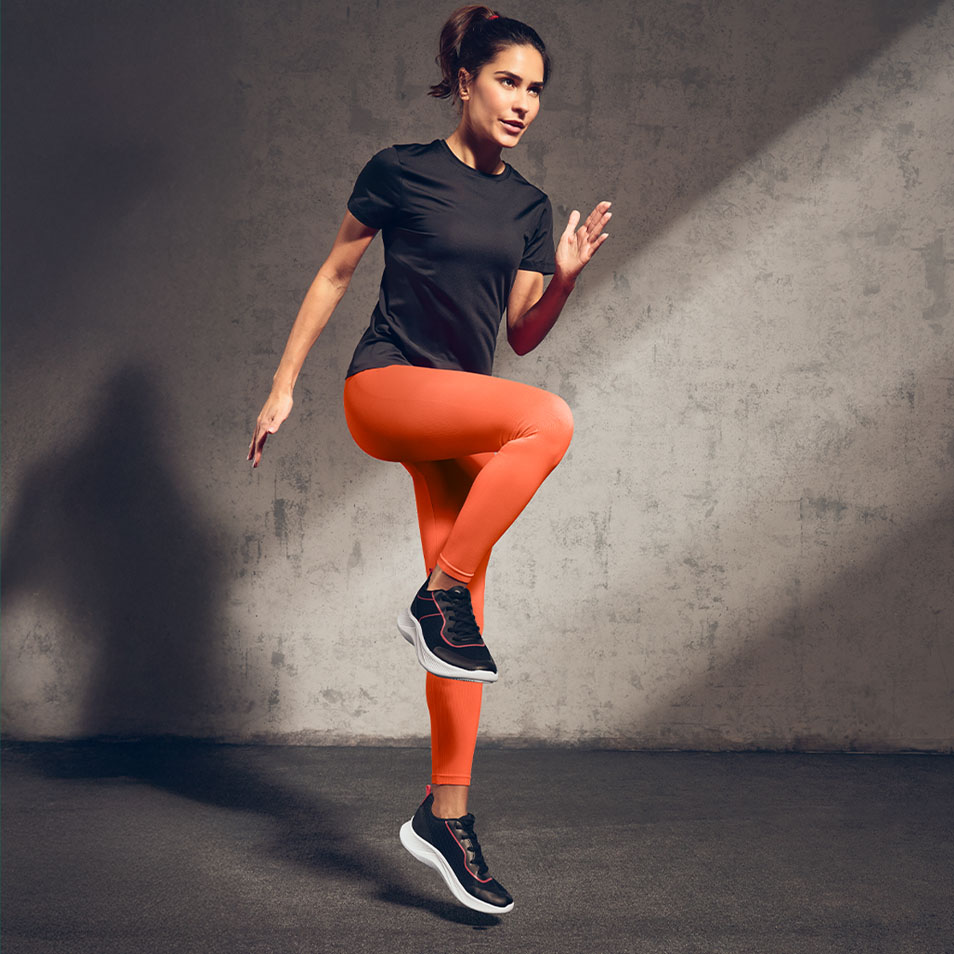 Woman in black sports t-shirt and orange leggings exercising