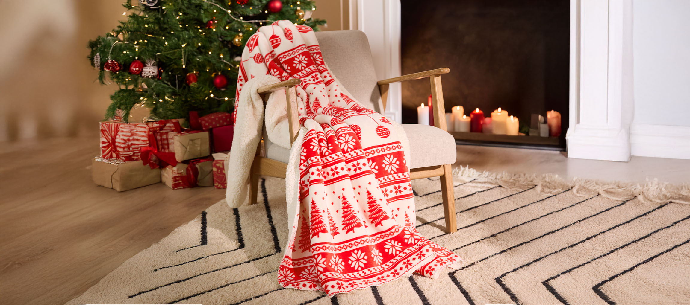 Christmas blanket on a chair, with a decorated tree and gifts in a cozy room.