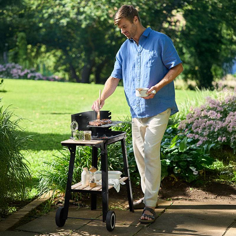 Man grilling steaks on a backyard barbecue.