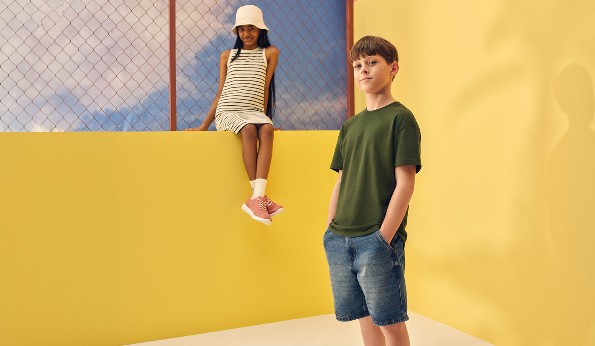Girl in striped dress and boy in t-shirt and denim shorts.